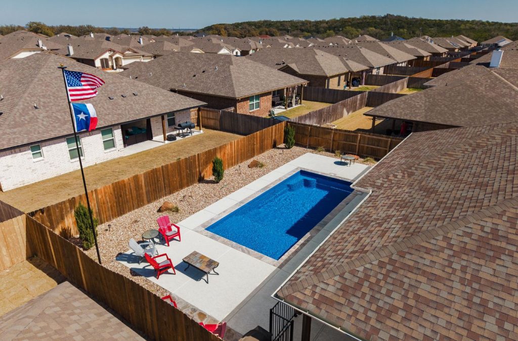A POOL-ology team member demonstrating the low-maintenance benefits of a fiberglass pool in Spring Trails, TX.