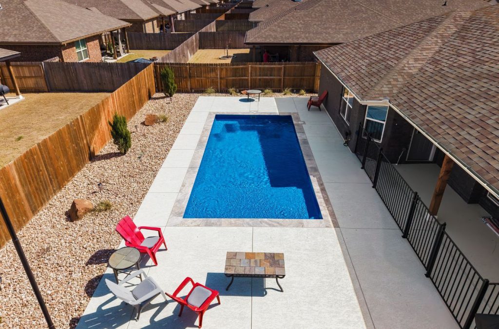 A POOL-ology crew member highlighting the durability and efficiency of fiberglass pool installation in Springbrook, TX.