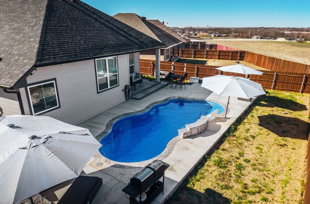 POOL-ology technician working on a fiberglass pool in Saxony, TX, creating a sleek and inviting backyard space.