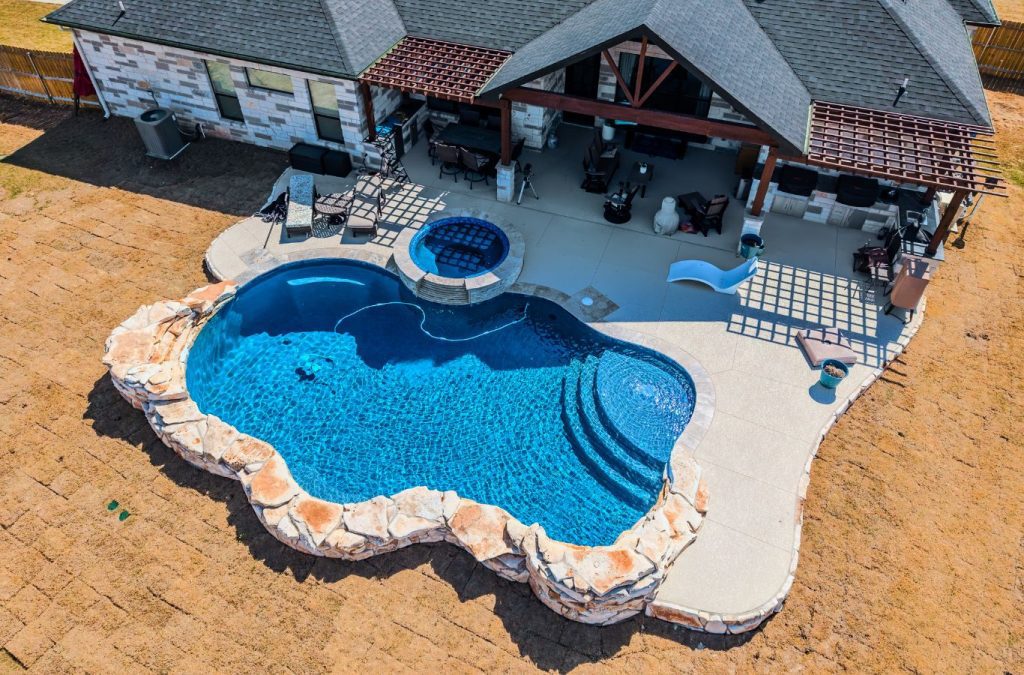 POOL-ology expert installing a fiberglass pool in Spring Trails, TX, showcasing a stylish backyard transformation.