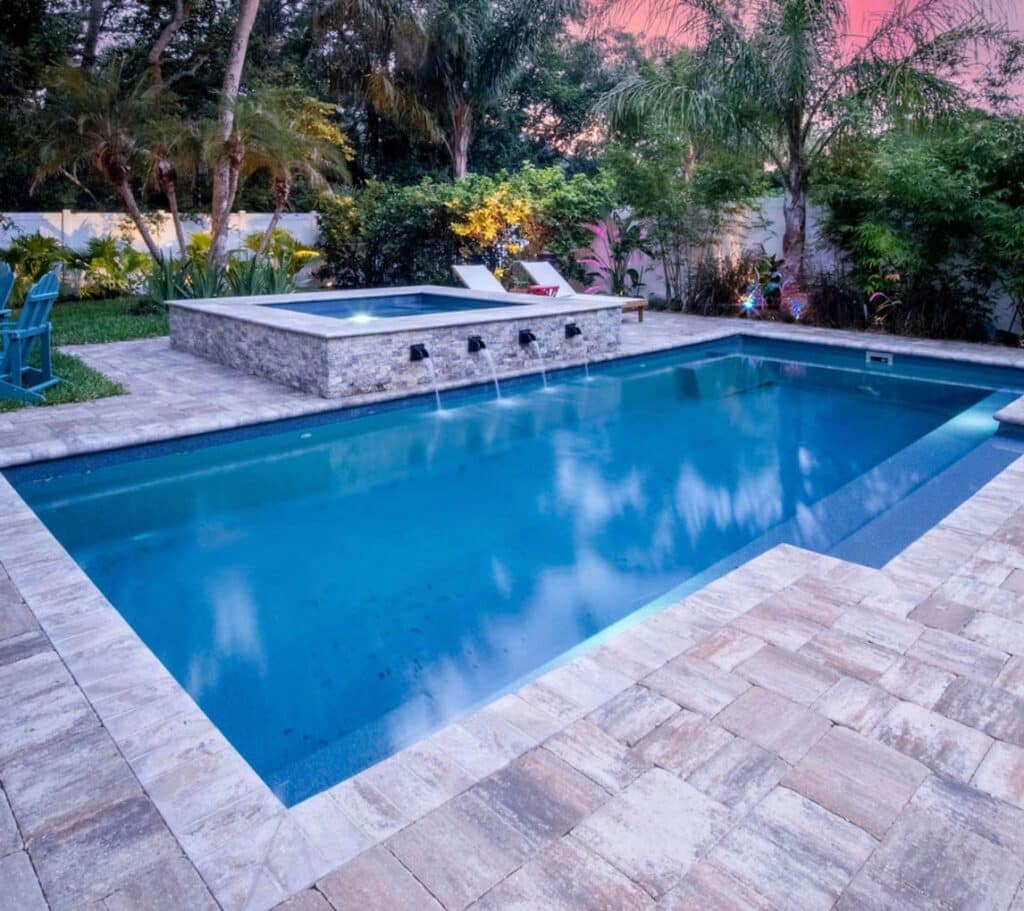 Tuscan 14.27 fiberglass pool, rectangular design with raised stone spa and four water spouts