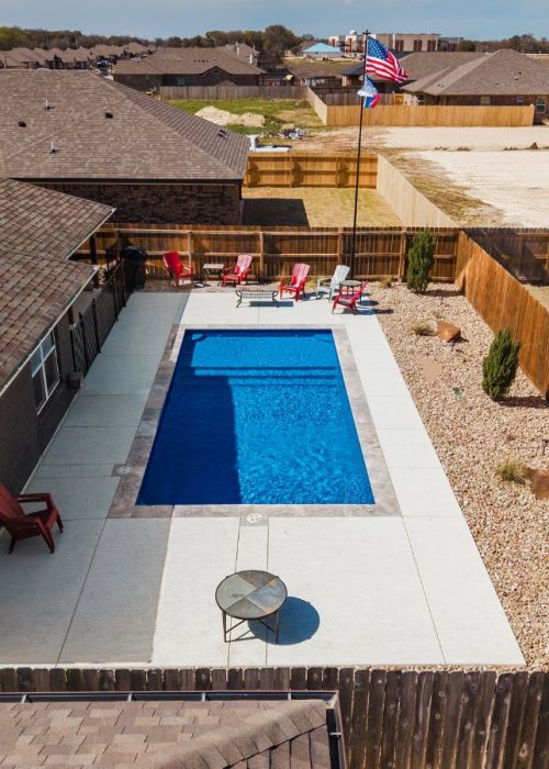 A POOL-ology team member showcasing a clean, energy-efficient fiberglass pool build in Heatherwilde, TX backyard.
