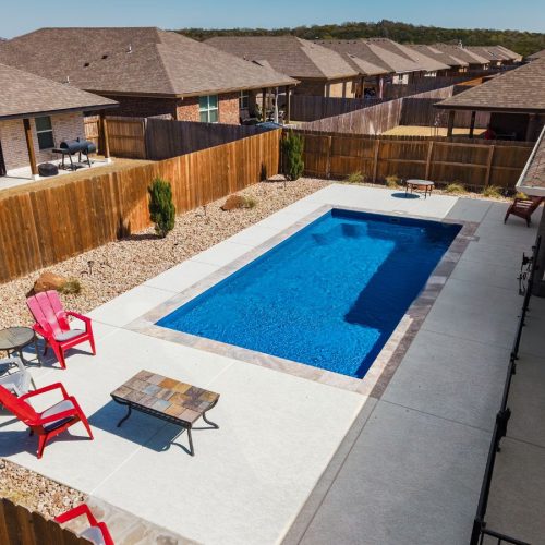 A POOL-ology professional installing a low-maintenance fiberglass pool in Saxony, TX, ideal for year-round relaxation.