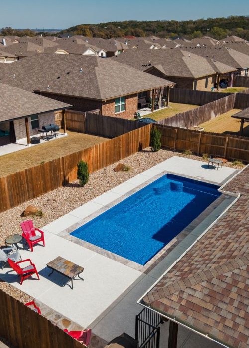 A POOL-ology team member demonstrating the low-maintenance benefits of a fiberglass pool in Spring Trails, TX.