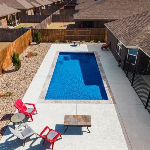 A POOL-ology crew member highlighting the durability and efficiency of fiberglass pool installation in Springbrook, TX.