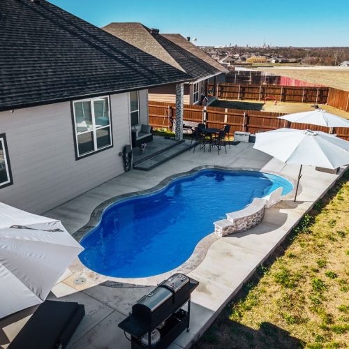 POOL-ology technician working on a fiberglass pool in Saxony, TX, creating a sleek and inviting backyard space.
